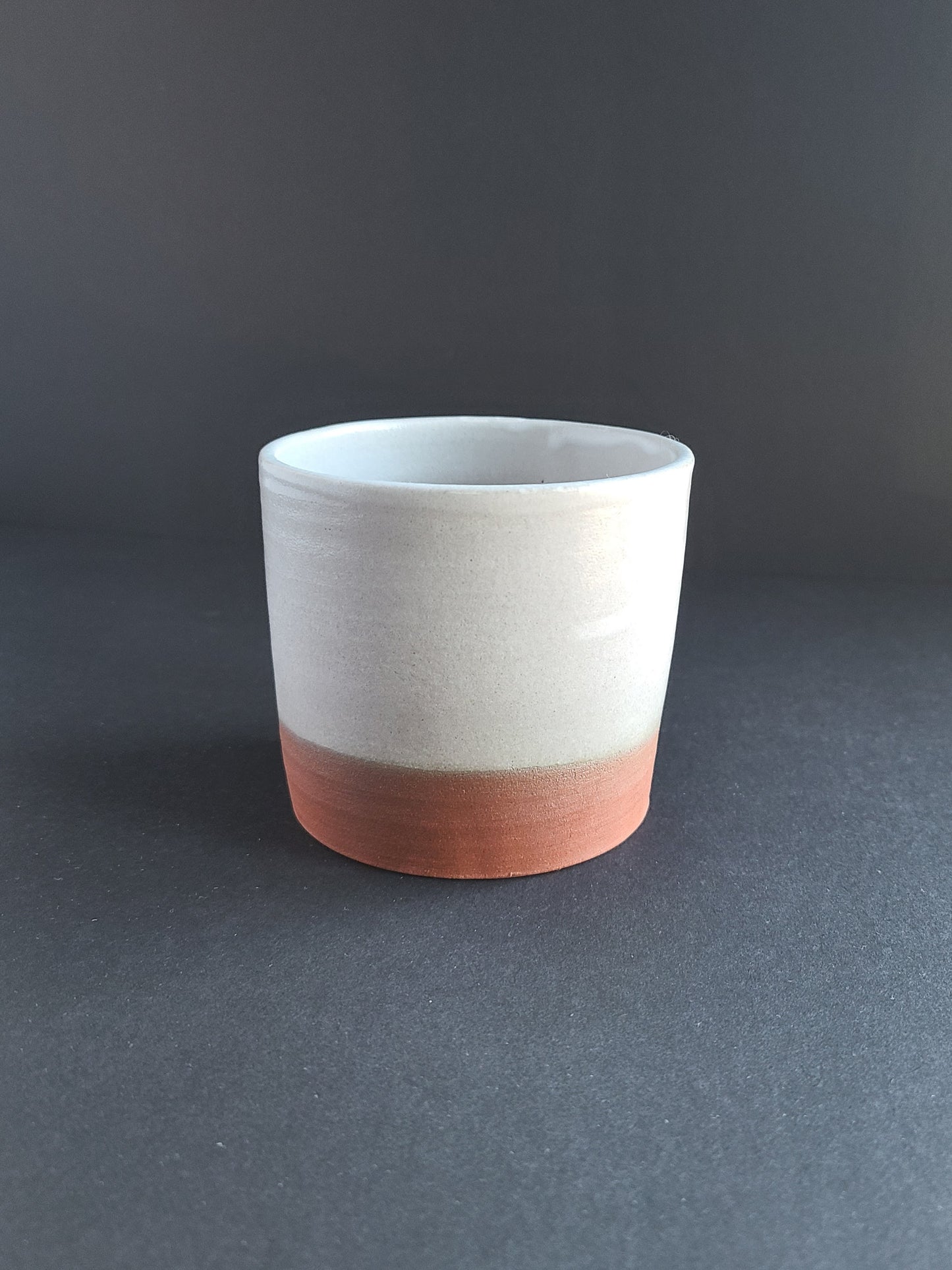 White cup in red stoneware